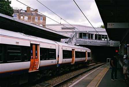 London Overground train with face covering notice on doors.