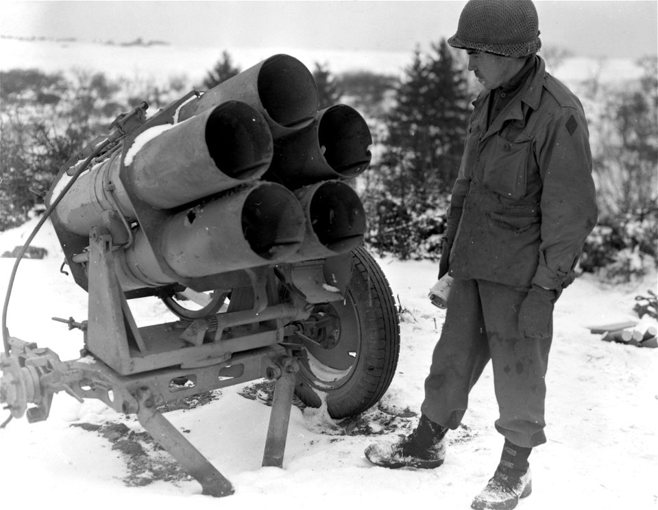 SC 199058-S - Pfc. Albert J. Smith, Uniontown, Pa., driver in combat photographic unit, looks over a 5 barrel German nebelwerfer which was captured by the 5th Inf. Div. troops, when they overran German positions near Mechelsberg, in Luxembourg.