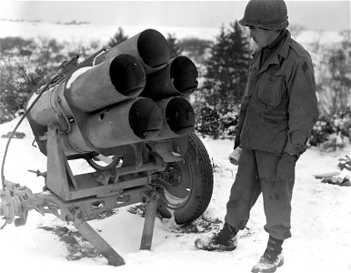 SC 199058-S - Pfc. Albert J. Smith, Uniontown, Pa., driver in combat photographic unit, looks over a 5 barrel German nebelwerfer which was captured by the 5th Inf. Div. troops, when they overran German positions near Mechelsberg, in Luxembourg. photo