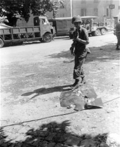 SC 270617 - A 3rd Division soldiers walks over a picture of Hitler in the streets of captured Brignoles. 19 August, 1944.