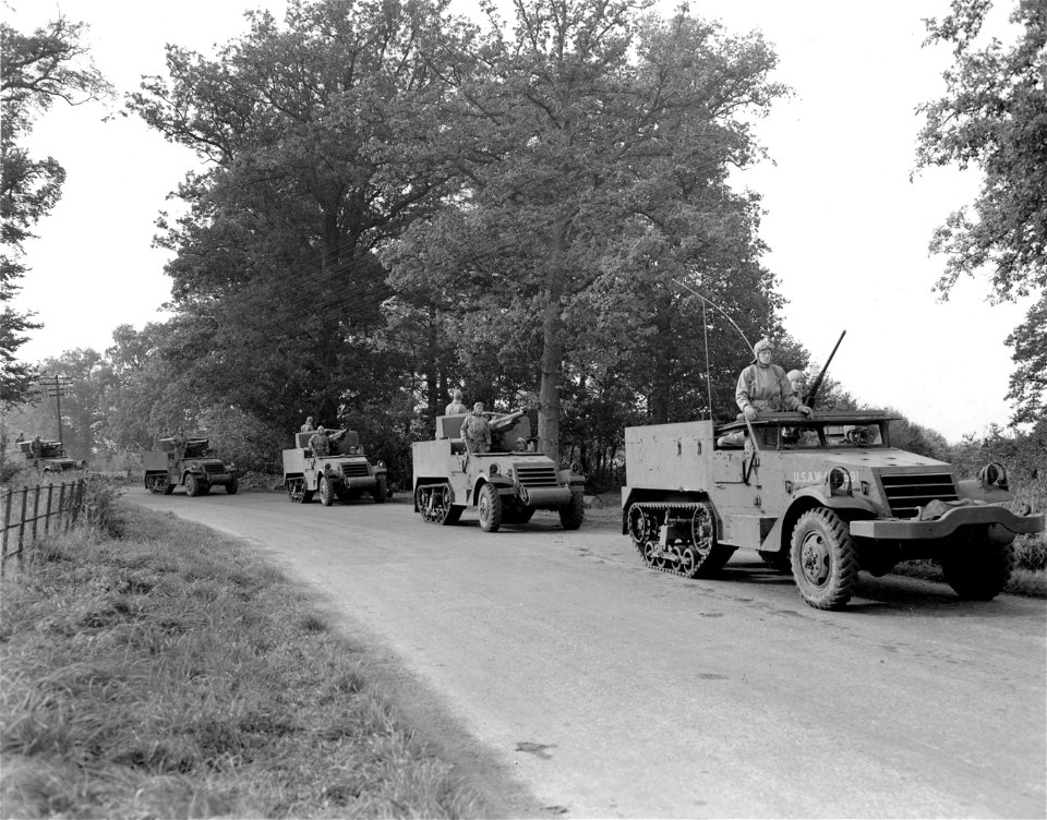 SC 151738 - Half track carriers of the 805 Tank Destroyer Bat, mounting 75mm guns round a bend in the road somewhere in England.
