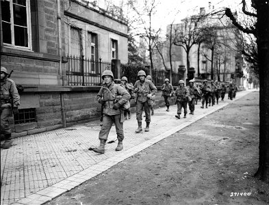 SC 271400 - Members of Company E, 324th Regiment, 44th Division, who are temporarily supporting a French Armored Division, march through the Strasbourg area of France. 24 November, 1944. photo