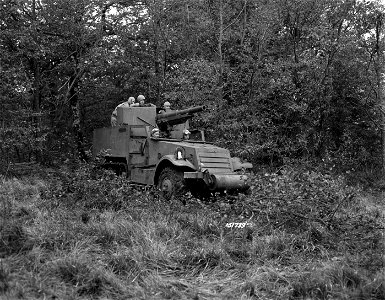SC 151739 - A half-track carrier is shown mounting a 75mm gun while rolling over a six-inch tree which it has felled as it emerges from the woods somewhere in England.