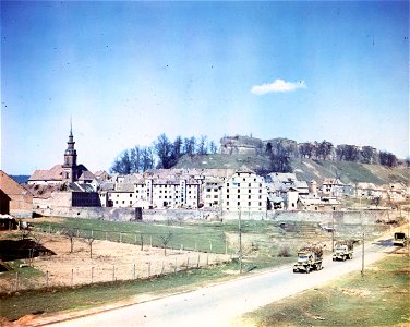 C-1089 - Fort de Bitche in the background and the city of Bitche in the foreground. G.I. trucks carrying P.O.W.s are on the road. 1945.