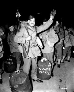SC 171518 - Cpl. Robert Lopez, native of Oriente, Cuba, displays flags of the United States and native Cuba as he waves goodbye on embarkation for overseas.