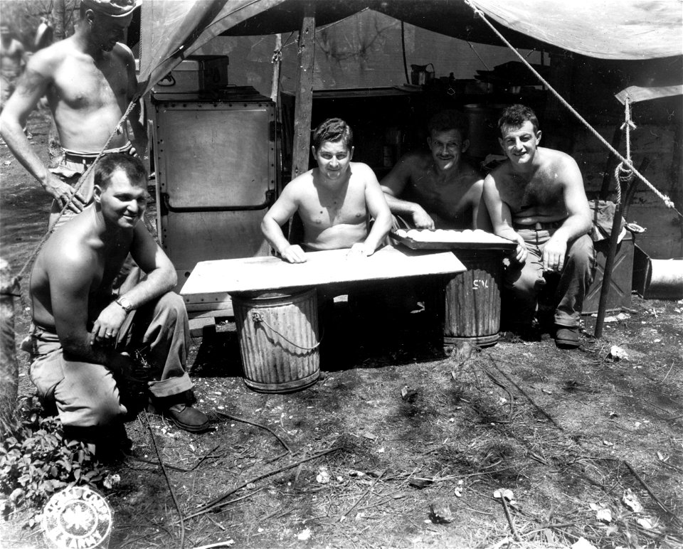 SC 335370 - Illinois men watch other Illini make biscuits, following the battle on Saipan.