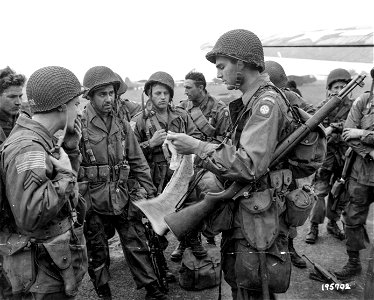 SC 195702 - Noncoms of the 82nd Airborne Div., Cottesmore, England, get some last minute sop details and instructions at an airfield in England where they are about to board a transport for the air invasion of Holland. photo