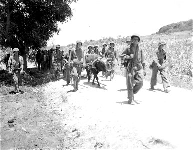 3rd Battalion, 23rd Marines, and oxen pulling their ammunition, march along road toward Jap positions. Saipan. June, 1944.