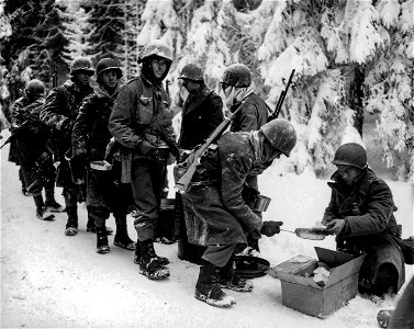 SC 198849 - Chow is served to American infantrymen on their way to La Roche, Belgium. 13 January, 1945.
