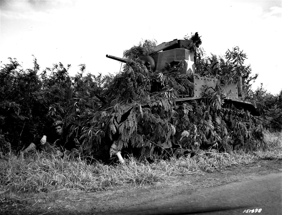 SC 151498 - Pvt. Harold J. Rice, left, and Cpl. James Childers taking a short rest after carefully camouflaging their tank during 34th Inf. maneuvers.