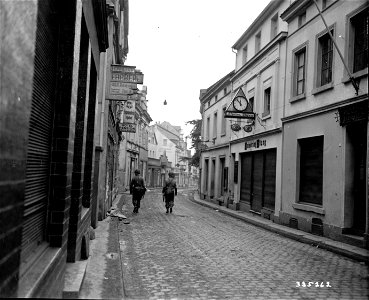 SC 335262 - Two U.S. First Army, 78th Infantry Division soldiers patrol a deserted street in Honnef, Germany on the east bank of the Rhine River. 12 March, 1945.