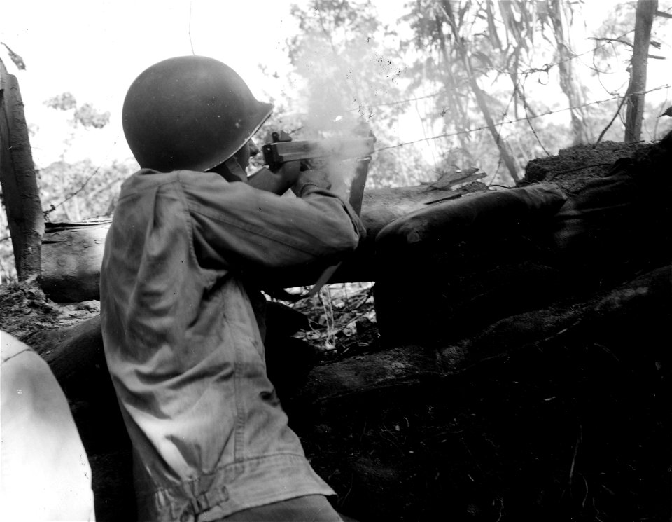SC 364612 - Tommy gunner from G. Co., 148th Inf., firing at Japs from pillbox on Bougainville.