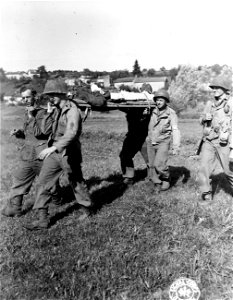 SC 195716 - Wounded prisoner being carried by German captives and Yank medics of 179th Inf., 45th Div. 22 September, 1944. Archettes, France. photo