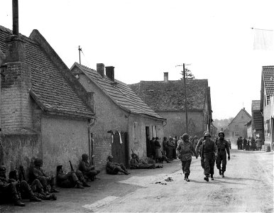 SC 335284 - 5th Infantry Division, 3rd U.S. Army troops rest in the streets of Hassloch, Germany, after the town was captured. 25 March, 1945. photo