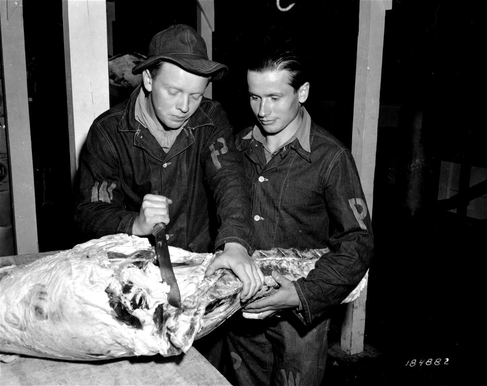 SC 184882 - German war prisoners at Camp Wallace, Texas, shown at work in the cold storage warehouse cutting a side of beef, part of which will go to their own kitchen. 1943.