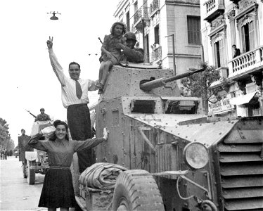 SC 171734 - A joyous father helped his small daughter onto a British armored car, while the young girl stood to salute Allied Armies as they entered Tunis, North Africa. 1943.