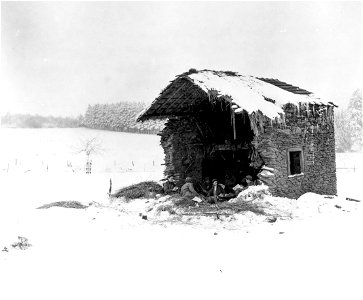 SC 198881 - A partially demolished barn, somewhere in Belgium, makes a temporary home for men of a light machine gun section of the 508th Parachute Infantry as reserves for the 82nd Airborne Division. 6 January, 1945.