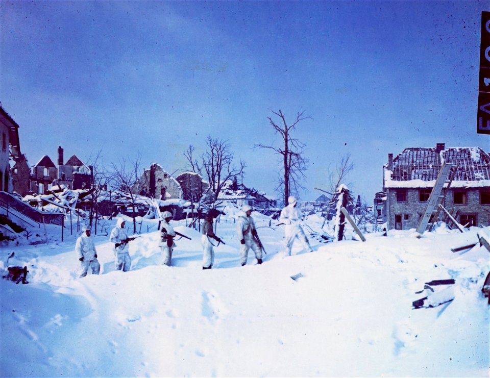 C-682 - Soldiers of Co. C, 48th Battalion, 7th Armored Division, garbed in snowsuits walk through the snow-covered streets of St. Vith, Belgium. 24 January, 1945. photo