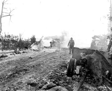 SC 199022 - Pvt. Thomas Amenta, 1391 S. Concord St., Los Angeles., Calif., of the 3rd Armored Div., hikes back to the rear area after his tank was knocked out by a road mine in the fighting beyond Langlir, Belgium... photo
