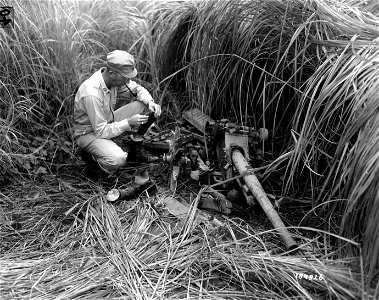 SC 184826 - The Japs were in a hurry when they left and did not bother to take the anti-tank gun being inspected by Capt. Walter Skielvig of Palo Alto, Cal., aide de camp to Maj. Gen. Fuller of the 41st Div. photo