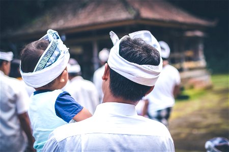 BALI, INDONESIA - JULY 4, 2018: Balinese children on a traditional ceremony. Baby with father. photo