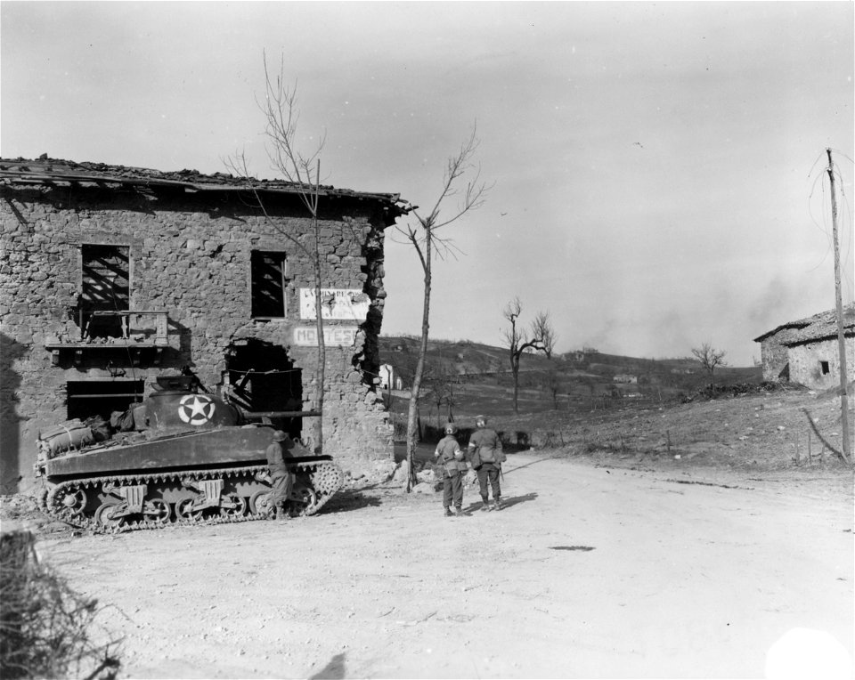 SC 270854 - Two medics and an infantryman look up road to watch American shell fire on a hill near Castel d'Aiano, during the assault by the 10th Mtn. Div. of this area. 3 March, 1945.