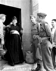 SC 180053 - Lt. Gen. Mark W. Clark, Maj. Gen. Alfred Gruenther and Lt. Col. Patrick J. Ryan present Monsignor Francesco Cuzzo with sum of money collected in 5th Army headquarters to repay damage done to his monastery by an American shell.