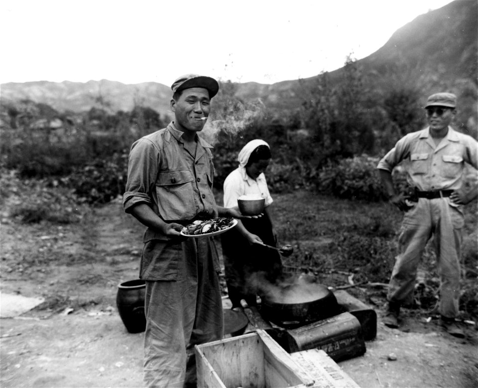 SC 348636 - Soldiers of the 15th Regt., 1st ROK Div., get their chow from a South Korean woman mess worker, north of Taegu, Korea. 18 September, 1950.