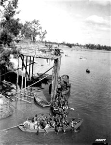 SC 166677 - Men loading equipment onto boats after they had descended from the landing nets for making a beach landing in a demonstration. Rockhampton, Australia. 19 November, 1942.