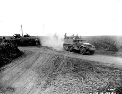 SC 151487 - Half-tracks and trucks move up to the front to knock out enemy positions during infantry maneuvers. Hawaii. photo