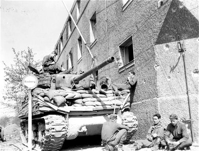 SC 337277 - Tankmen of the 781st Tank Battalion, supporting the 100th Infantry Division, relax while awaiting the construction of a new bridge across the Neckar River in Heilbronn, Germany.