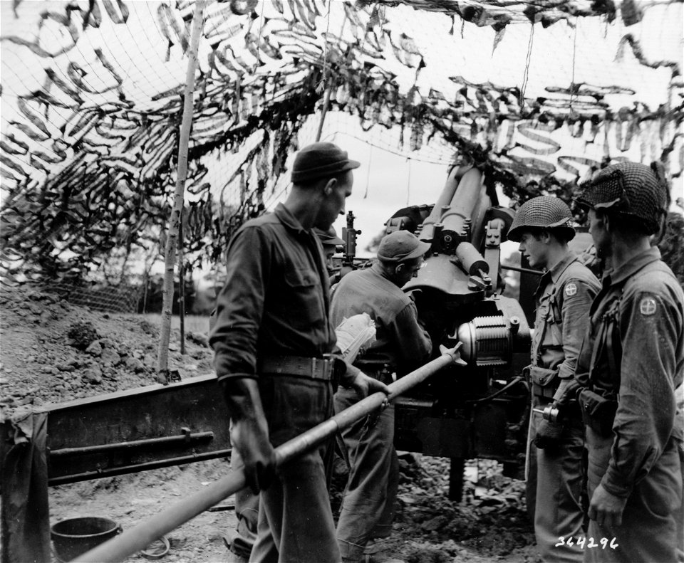 SC 354296 - On the artillery front of the fierce St. Lo offensive. Crew of a heavy 155mm gun watch gunner insert 85 pound projectile into breach...