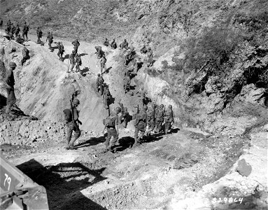 SC 329864 - Troops of the 3rd Division, 7th Infantry, advancing toward Avellino, bypass a bridge being repaired after the Germans blew it up to impede American forces. Italy. 3 October, 1943.