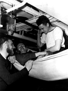 SC 364138 - Pte. William Wyatt, lower Sackville, Halifax, center, veteran with five and one half year's service in the Navy during World War II, tries out familiar hammock during visit with Petty Officer Ed Randall, Halifax, N.S., left, and...