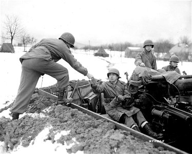 SC 374805 - Capt. Bernward W. Heberer, Perkin, Ill., OO of Battery "A," 553rd AAA AW Battalion, hands Cpl. Elmer Manweiler, Sugar City, Colo., his pay.