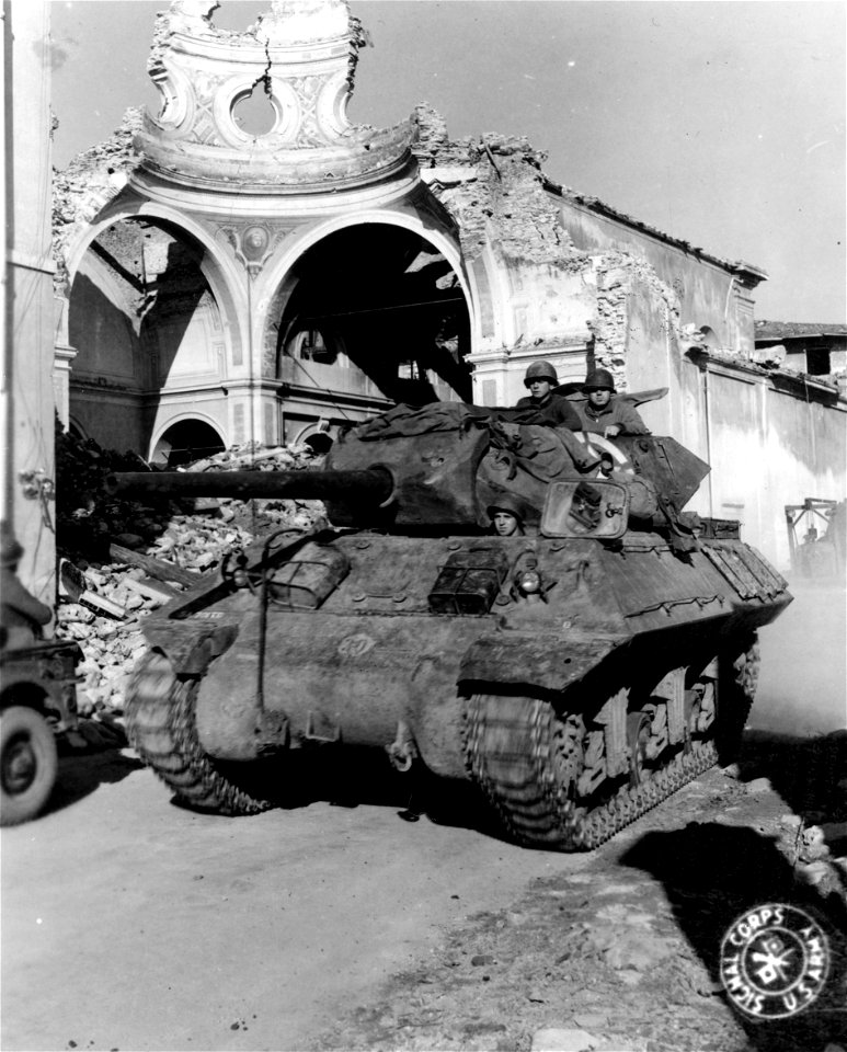 SC 329837 - A M-10 tank destroyer of the 701st Tank Bn., passes a destroyed church in Querceta as it moves forward to a new position in support of 92nd Inf. Div. 8 February, 1945.