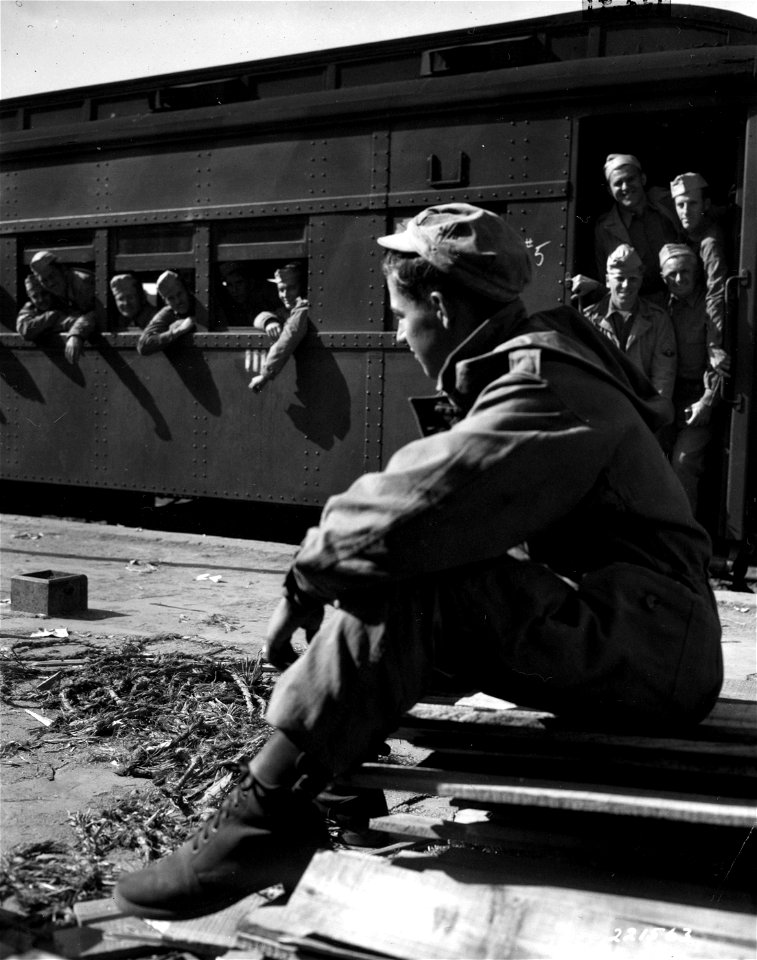 SC 221563 - Pfc. Pete Counellis, 1424 Wentworth, Chicago, Ill., dejectedly watches train carrying home-going vets.