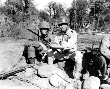 SC 337218 - Major General Charles L. Mullins, Jr., CG, 25th Infantry Division, points out the meaning of the insignia on a captured Japanese officer's saber to Lt. Col. V. L. Johnson, G-3 Officer, 25th Inf. Div., from Albany, N.Y. photo