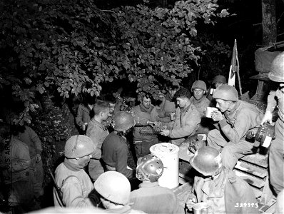 SC 329773 - Members of the 80th Reconnaissance Unit fall in line for doughnuts and and coffee furnished from an American Red Cross Clubmobile in the vicinity of the Moselle River, France. 8 September, 1944. photo