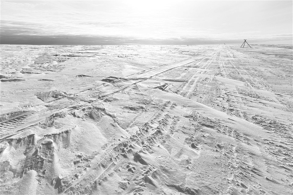 Snowmachine tracks along a winter trail route.
