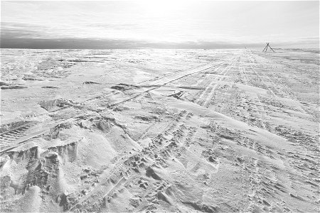 Snowmachine tracks along a winter trail route.