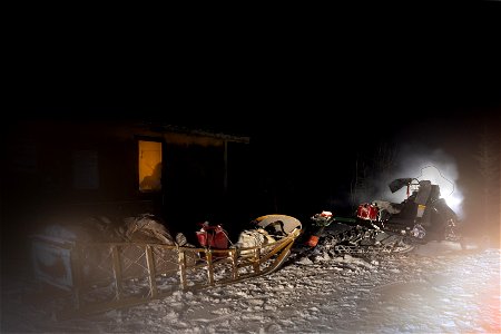 Snowmachine and sled at night photo