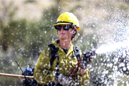 MAY 15: Female firefighter with hose photo