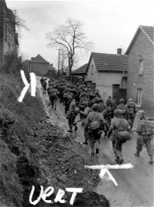SC 337321 - Group of about 75 German prisoners are marched through street in Bonn, Germany, by infantrymen of the 1st Division, 1st U.S. Army. photo