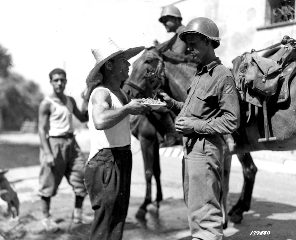 SC 179880 - On outskirts of Messina, joyful Italians offer spaghetti dinners to soldiers "on the hoof" just before their entry into Messina, Sicily.