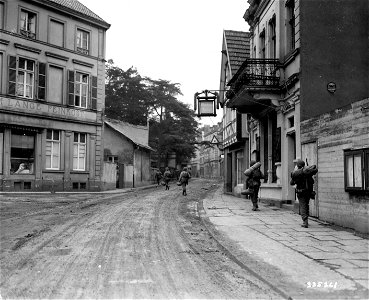 SC 335261 - Reinforcements for the 78th Infantry Division, U.S. First Army, pass through Honnof, Germany, while constant enemy shelling is going on. Honnef is on the eastern side of the Rhine River. photo
