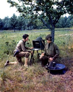 C-854 - Two members of the Signal Corps during training in the field operate a field telephone switchboard. photo