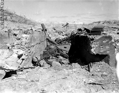 SC 374601 - GIs lying between chunks of masonry for protection on Corregidor island, while under fire from a Jap strong point. 16 February, 1945.