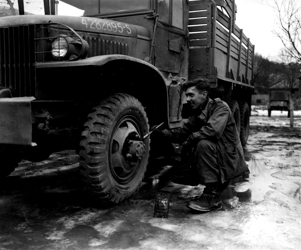 SC 374721 - The paint job on the wheel of this First Army truck is touched up by Pfc. Lawrence J. Morris, 3449 Marshall Road, Upper Darby, Pa., 83rd Quartermaster Depot, 83rd Infantry Division.