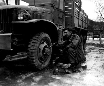 SC 374721 - The paint job on the wheel of this First Army truck is touched up by Pfc. Lawrence J. Morris, 3449 Marshall Road, Upper Darby, Pa., 83rd Quartermaster Depot, 83rd Infantry Division. photo